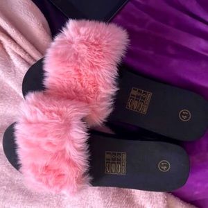 Pink faux fur slides.